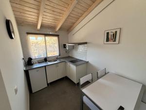 una pequeña cocina con armarios blancos y una mesa en Vivienda Vacacional Carla 2, en Arucas