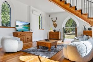 a living room with a couch and a table at St Patrick's Church - Hawea Flat in Hawea Flat