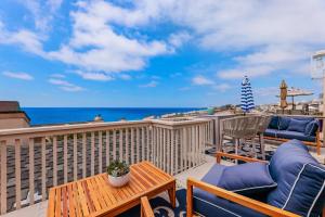 a balcony with a table and chairs and the ocean at Solana Escape - SUR44 in Solana Beach