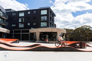 a person riding a bike on a ramp in front of a building at Mountain Retreat Suitable for 2 Families, Sleeps 8 in Mount Buller