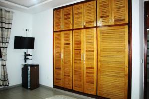 アビジャンにあるRésidence Vanestelleのランプのある部屋にある大きな木製のクローゼット +3枚の写真