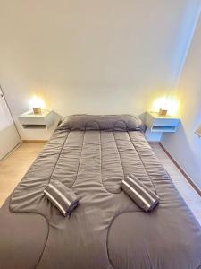 a large bed in a room with two tables at Amoblado Temporal M&S 4 M in Neuquén