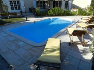 a swimming pool with lounge chairs next to it at Les Broussous in Sauve