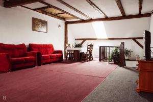 a living room with red couches and a table at Siedlisko Waliszówka in Bystrzyca Kłodzka