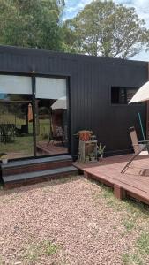 una casa negra con terraza y patio en Cabaña 2 cuadras de la playa, en Piriápolis