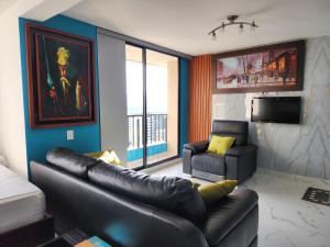 a living room with a leather couch and a tv at 1901Luxury Cerca Clínica Foscal & Ardila Lulle in Floridablanca