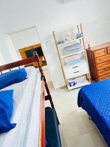 une chambre avec un lit et un réfrigérateur ouvert dans l'établissement Apartamento em Guarujá Centro, à Guarujá