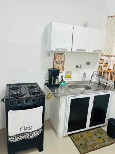 une cuisine avec une cuisinière et un évier dans l'établissement Apartamento em Guarujá Centro, à Guarujá