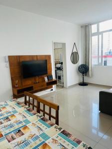 - un salon avec une table et des photographies dans l'établissement Apartamento em Guarujá Centro, à Guarujá