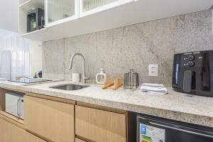 a kitchen with a sink and a microwave at Studio Reformado perto das melhores praias do Rio de Janeiro com Wi-fi Rápido in Rio de Janeiro