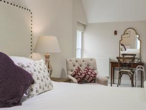 a bedroom with a bed and a chair and a mirror at Harlech Apartments - Efnisien in Harlech