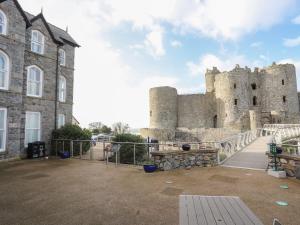 a castle with a fence in front of it at Harlech Apartments - Efnisien in Harlech