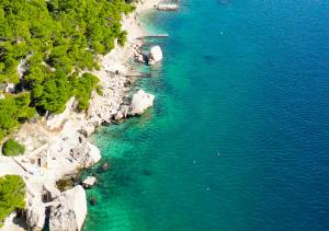 an aerial view of a beach with rocks and water at holiday by the sea in Marusici  +83 photos