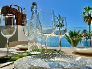 a table with wine glasses and plates on a table at Callao Ocean View Luxury, air condition, wifi in Callao Salvaje