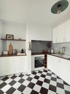 a kitchen with a black and white checkered floor at Casa D'Avó Bá in Évora