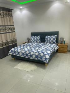 Un dormitorio con una cama con un edredón azul. en Villa Cissé, en Saly Portudal 26 fotos más