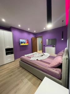 a bedroom with purple walls and a large bed at Gold Apartment Tirana in Tirana +41 photos