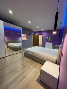 a bedroom with two beds and a purple wall at Gold Apartment Tirana in Tirana