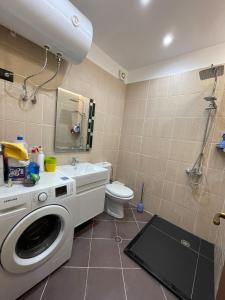 a bathroom with a washing machine and a toilet at Gold Apartment Tirana in Tirana