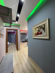 a room with a painting on a wall with green lights at Gold Apartment Tirana in Tirana