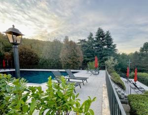 a swimming pool with benches and a light pole at Como Lake - Villa Maderni lake view in Como