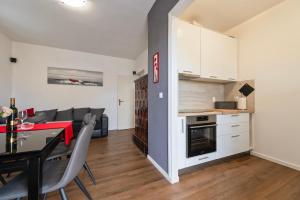 eine Küche und ein Wohnzimmer mit einem Tisch und einer Couch in der Unterkunft Apartment Marinsko in Veli Iž