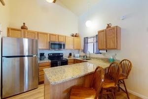 a kitchen with a stainless steel refrigerator and wooden cabinets at Pines 4058 in Pagosa Springs