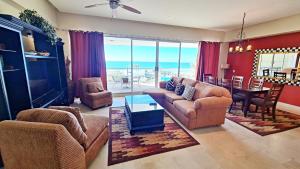 ein Wohnzimmer mit Sofa, Stühlen und einem Tisch in der Unterkunft Encanto Living 304 Spacious, 2 Bedroom Ocean View!! in Playa Encanto