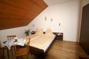 1 dormitorio con cama y mesa pequeña en Gasthof zur Post en Hinterstoder