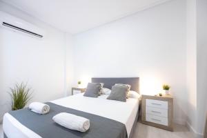 Łóżko lub łóżka w pokoju w obiekcie Apartamentos Marina Playa de Torrevieja by Apartamentos Torrevieja