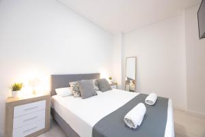 Łóżko lub łóżka w pokoju w obiekcie Apartamentos Marina Playa de Torrevieja by Apartamentos Torrevieja