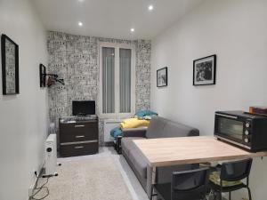Una pequeña sala de estar con un sofá y una mesa. en Logement entier Pantin, en Pantin