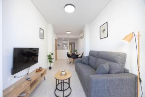 salon z kanapą i telewizorem w obiekcie Apartamentos Marina Playa de Torrevieja by Apartamentos Torrevieja w mieście Torrevieja