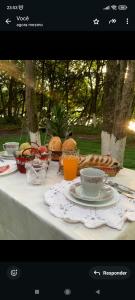 a table with cups and plates of food on it at Pousada da vila in Abelardo Luz