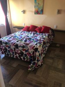 ein Bett mit farbenfroher Bettdecke in einem Schlafzimmer in der Unterkunft Cabañas del Bosque in Santa Teresita + 2 Fotos