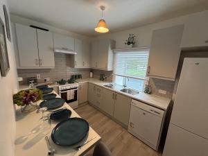 a kitchen with white cabinets and a counter top at Cahir Cosy Cottage in Cahir