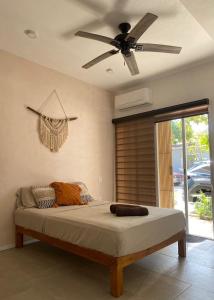 a bedroom with a bed with a ceiling fan at Habitat in Barra de Navidad