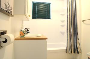 a bathroom with a sink and a bath tub at Logis des prodiges - Le 775 in Rouyn-Noranda