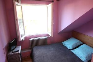 a small bedroom with a bed and a window at Auberge Normande in Valframbert