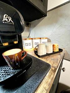 a coffee cup sitting on a counter next to a coffee maker at Charmant studio 30m2 in Clermont-Ferrand