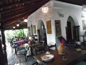 a restaurant with tables and chairs in a room at The Dream House in Unawatuna
