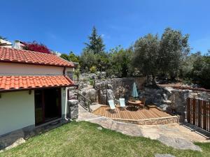 a garden with a wooden deck and a house at Suite Pedra Oliveira - Piscine salée privée - Proche Coimbra - Centre Portugal in Ameixeira