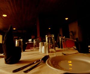 - une table avec une plaque blanche et des ustensiles dans l'établissement Shalimar Hotel, à Colombo