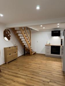 a room with a staircase and a kitchen with wooden floors at Isaak Apartment Lottstetten in Lottstetten