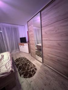a bedroom with a large mirror and a bed at Apartament MaGiFa Constanța in Constanţa
