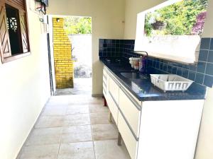 a kitchen with a sink and a counter top at Porto Mirim House in Ceará-Mirim