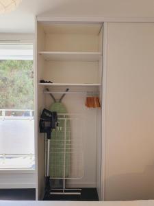 Cette chambre comprend un placard avec un ventilateur et une fenêtre. dans l'établissement T2 cœur de ville moderne CLIM WIFI Terrasse - ROSSIconciergerie - Linge en option, à La Grande Motte