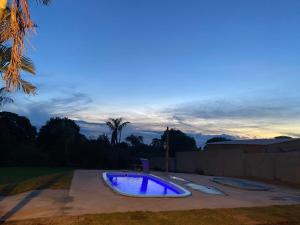 a large blue pool in a yard at dusk at Chácara Andorinhas São Pedro SP in São Pedro