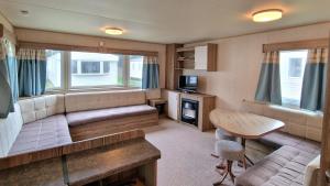 a living room with a couch and a table at Bella Family Getaway, Church Farm in Pagham +7 photos