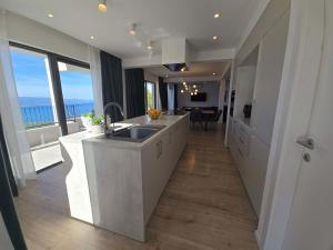 a kitchen with a sink and a view of the ocean at Villa Adria Horizon in Bast